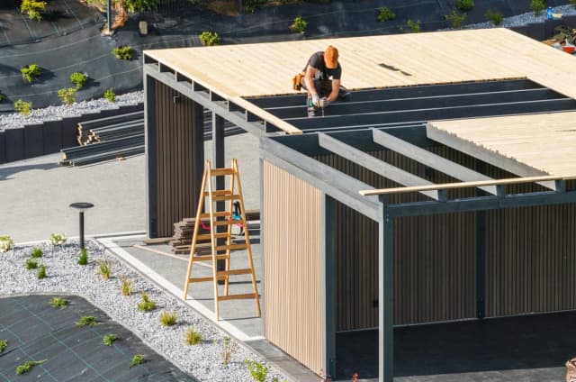 Builder installing the roof on a modern prefab home
