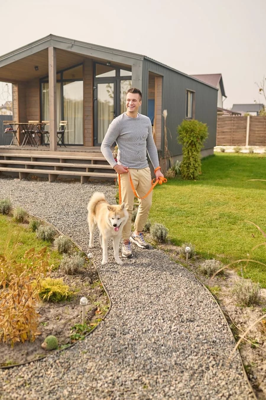 Homeowner with dog outside a finished prefab house